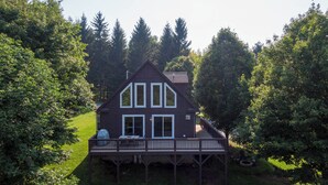 A two-story house with a deck, surrounded by trees. - 4 Bears Lodge (Banner Elk)