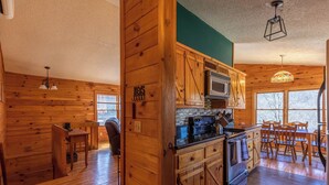 L’intérieur d’un chalet en bois comprend une cuisine, un coin repas et un espace salon confortable.