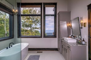 A modern bathroom with a freestanding bathtub, a large mirror, and a vanity with a sink. - Elevated Elk at Monteagle (Banner Elk)