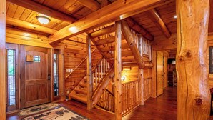 Ein Holzinnenraum mit Treppe, Holztüren und einem Teppich auf dem Boden.