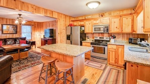 L’intérieur d’un chalet en bois comprend une cuisine, un coin repas et un salon.