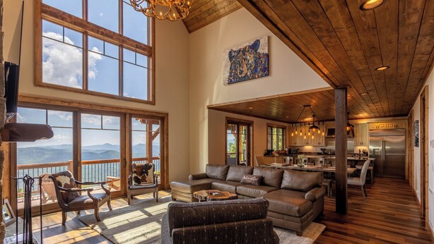 A spacious living area with large windows, a wooden ceiling, and a view of the mountains. - Majestic View Hideaway at Eagles Nest (Banner Elk)