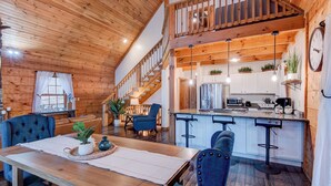 A wooden interior with a dining area, kitchen, and staircase. - Beaver Rock Lodge (Elk Park)
