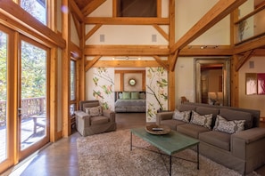 A spacious living room with a large wooden ceiling, a sofa set, a coffee table, and a fireplace. - Cedar Rock Townhomes at Eagles Nest (Banner Elk)