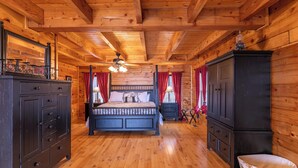 Habitación con paneles de madera, una cama, un aparador y un armario.