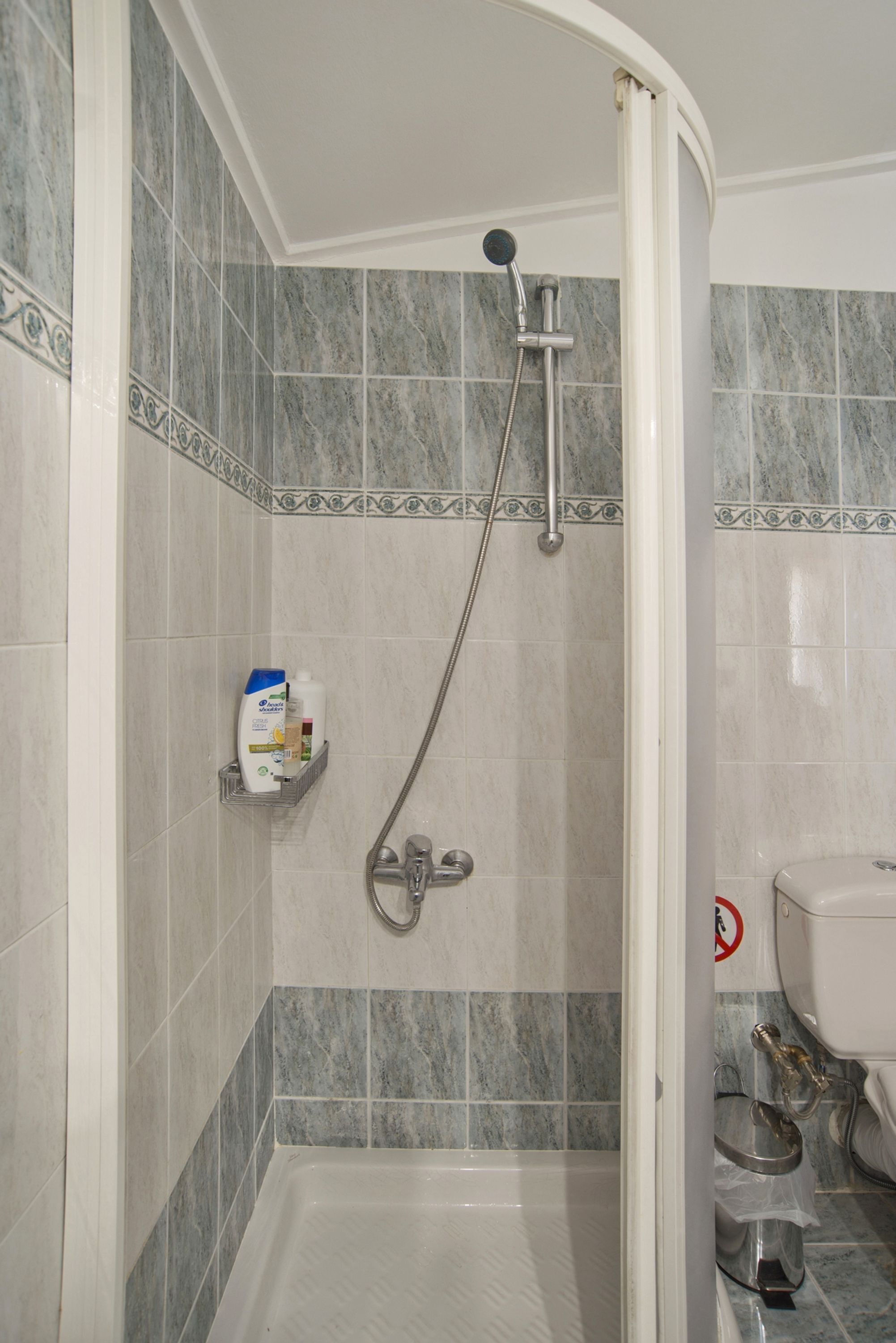 A bathroom with a shower, a toilet, and a sink.