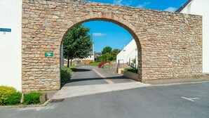 A stone archway leading to a street with a sign reading "A STERNE 11". - Le P'tit Loup de Mer - Appt proche plage, terrasse (Saint-Nic)