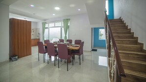 Un comedor con una escalera de madera y vistas al exterior.