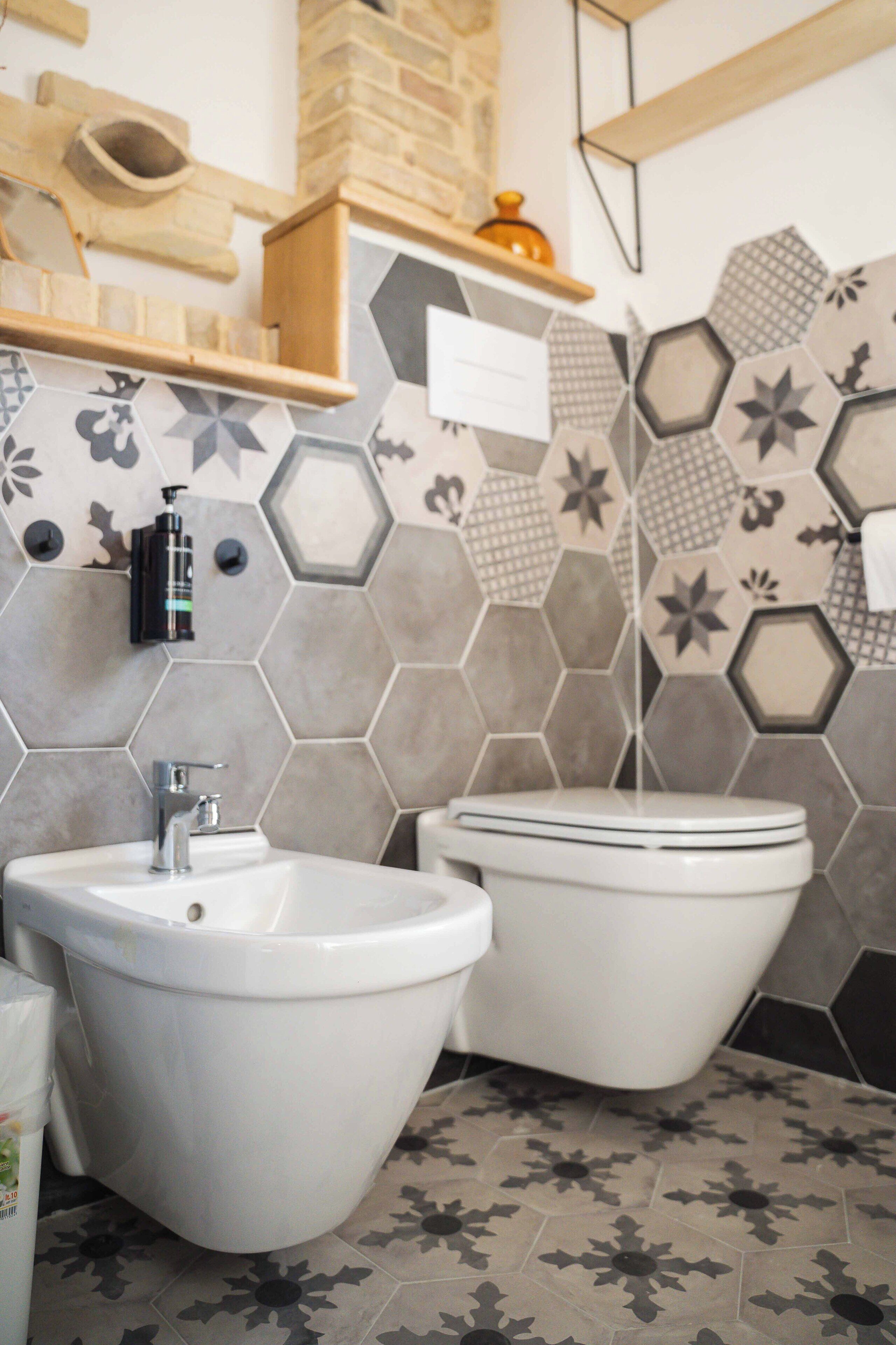 A bathroom with a bidet, toilet, and a sink.