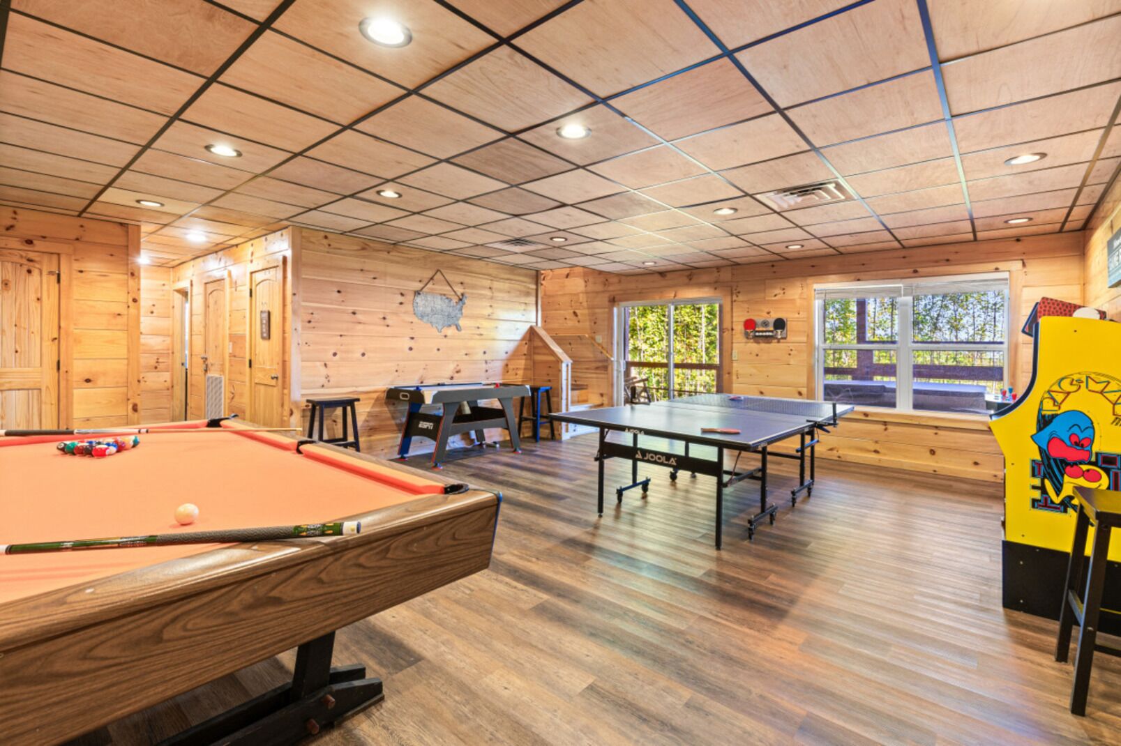 A wooden interior with pool tables and a ping pong table.