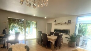 A spacious living room with a chandelier, wooden coffee table, and comfortable seating.