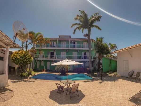 A two-story building with a swimming pool, outdoor seating, and a satellite dish. - Pousada Terra Nostra (Prado)