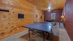 A ping pong table in a room with wooden walls and a billiards table. - Uncle Johns Cabin (Vilas)