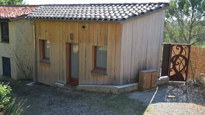 A wooden building with a tiled roof, a door, and windows.