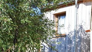 A rustic wooden house with a wooden deck and a staircase leading to the entrance.