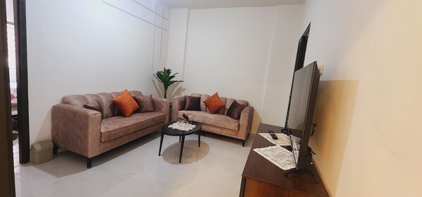 A living room with two sofas, a coffee table, a floor lamp, and a large mirror.