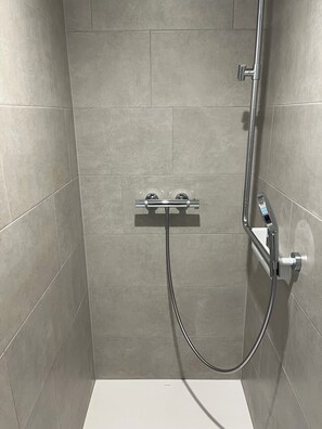 Dusj, håndklær, sjampo og toalettpapir