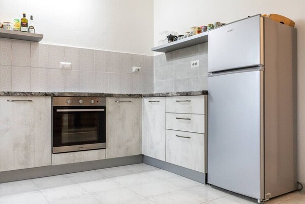 Een koelkast, een oven, een kookplaat, een koffiezetapparaat/waterkoker