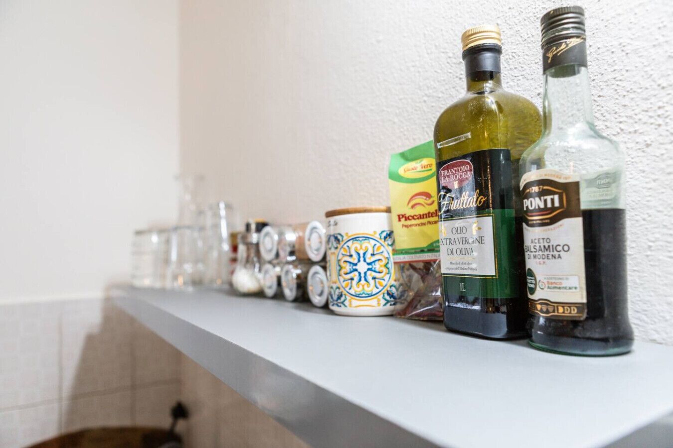 A kitchen counter with various bottles, jars, and containers.