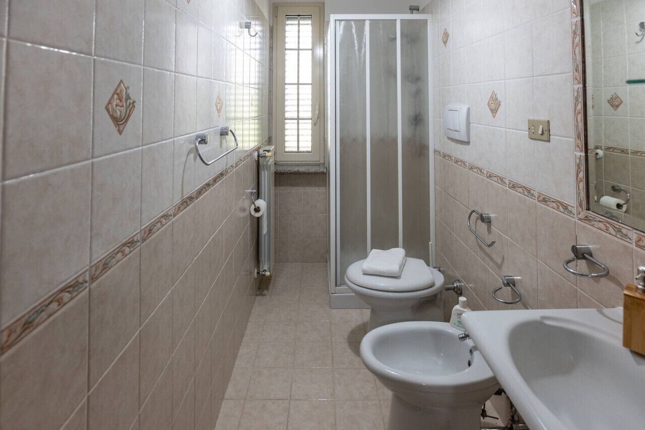 Une salle de bain équipée d’une douche, de toilettes, d’un bidet et d’un lavabo.