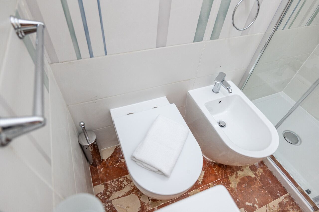 Une salle de bain équipée de toilettes, d’un bidet et d’une douche.