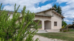 A building with a light-colored facade, a sloped roof, and a small porch area. - Villa D`Angelo - Quadrupla (Miracoli)