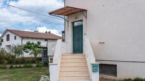 A white building with a green door and a set of beige stairs leading to a covered entrance. - Villa D`Angelo - Quadrupla (Miracoli)