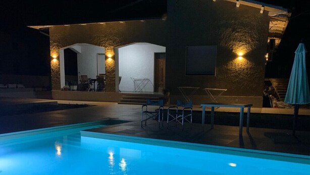 A swimming pool with a patio area, including seating and a small building with exterior lighting. - Villa D`Angelo - Quadrupla (Miracoli)