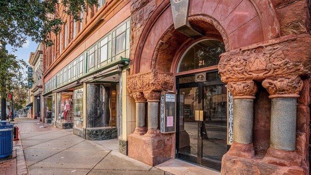 Un edificio histórico con columnas ornamentadas y una amplia entrada en arco.