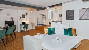 A modern hotel room with a large bed, a dining area, and a seating area. - flair Alte Brauerei I Old town I free parking lot I coffee I WiFi I Xbox IDisney (Kitzingen)