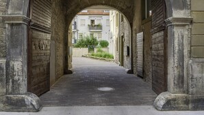 An arched stone corridor with wooden doors, leading to a building with a tiled roof and balconies. - flair Alte Brauerei I Old town I free parking lot I coffee I WiFi I Xbox IDisney (Kitzingen)
