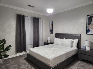 Relax in a serene space with a large bed, two bedside tables, and a potted plant.