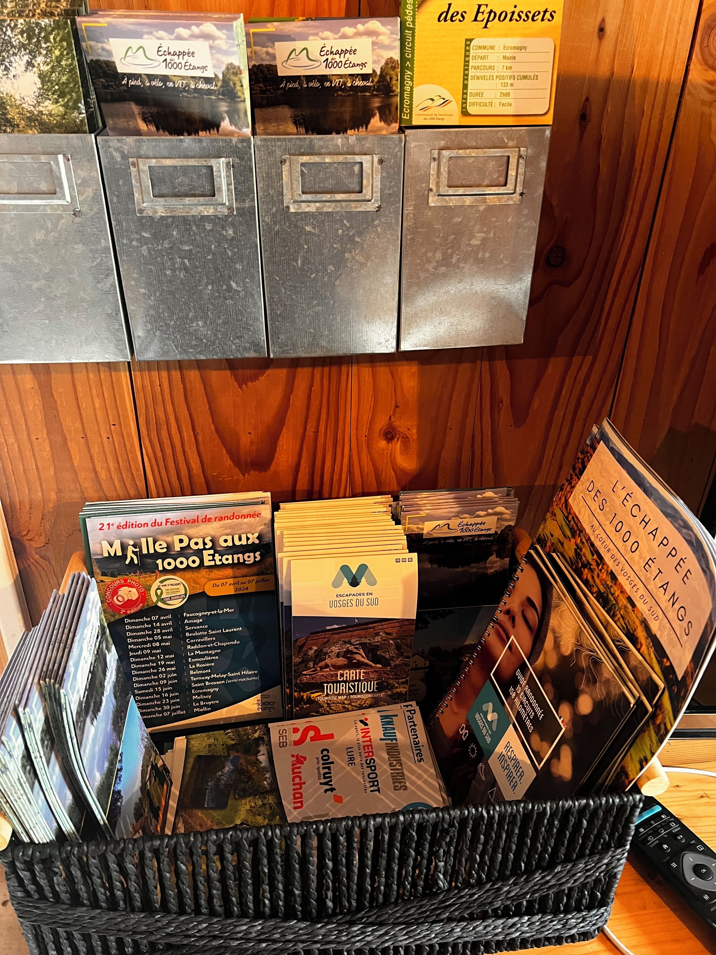 Een verzameling reisbrochures en kaarten, waaronder 'Echappée 1000 Etangs' en 'L'Echappée des 1000 Etangs', wat wijst op activiteiten op en rond het water.