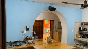 A kitchen with a gas stove, wooden countertop, and a ceiling fan. - Casa Samay Cozumel (Cozumel)
