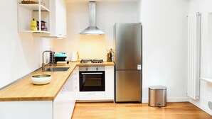 Eine moderne Küche mit Edelstahl-Kühlschrank, Backofen und Gasherd.