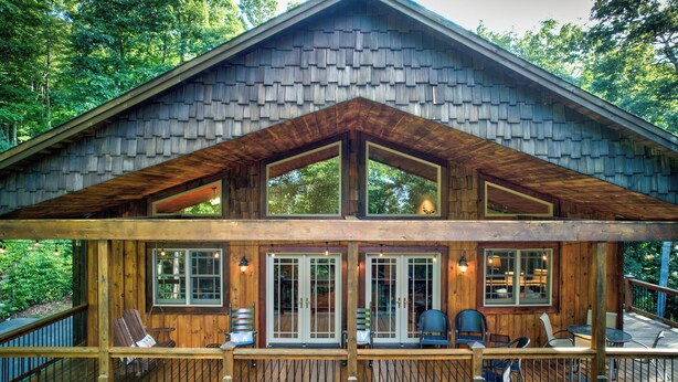 A wooden cabin with a covered deck, large windows, and outdoor seating. - High On Cloud Nine (Boone)