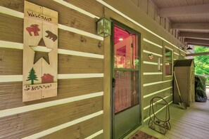 A wooden cabin with a welcoming sign featuring animal silhouettes and a star. - Kaylee's Kabin (Vilas)