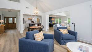 A spacious living room with blue sofas, a dining area, and a kitchen in the background. - Close to the Beach! (Hilton Head Island)