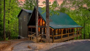 Une cabane dotée d’un toit végétalisé, d’un porche et d’un escalier menant à l’entrée.