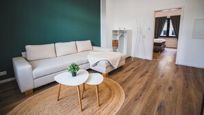 Un salon moderne avec un canapé, une petite table et une plante.