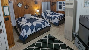 A cabin-style room with two beds, a ceiling fan, a heater, and a refrigerator. - Cozy Studio Cabin #5 Riverside Point Resort (Park Rapids)