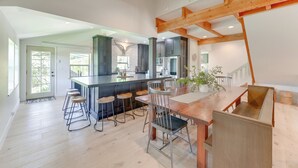 A modern kitchen with a central island, bar stools, and a dining table with chairs. - Salt River Access: Mtn-View Star Valley Cabin! (Thayne)