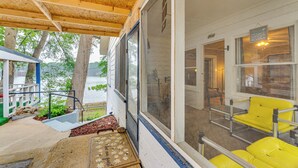 A covered porch with a wooden ceiling, a view of the river, and yellow chairs. - Lakefront Cottage in Clear Springs w/ Deck & Patio (New Braunfels)