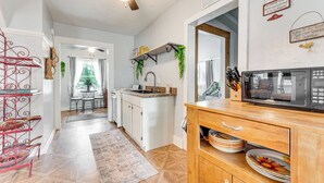 A modern kitchen with white cabinets, a wooden countertop, and a ceiling fan. - Lakefront Cottage in Clear Springs w/ Deck & Patio (New Braunfels)
