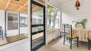 A room with a wooden ceiling, a door with a 'COME Back!' sign, a table with chairs, and a window with a view of trees. - Lakefront Cottage in Clear Springs w/ Deck & Patio (New Braunfels)