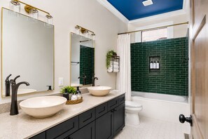 Une salle de bain avec deux lavabos, une baignoire et une douche.