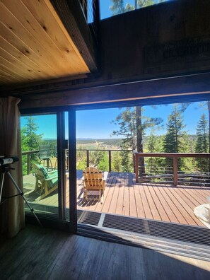 A wooden deck with a view of a forest and mountains.