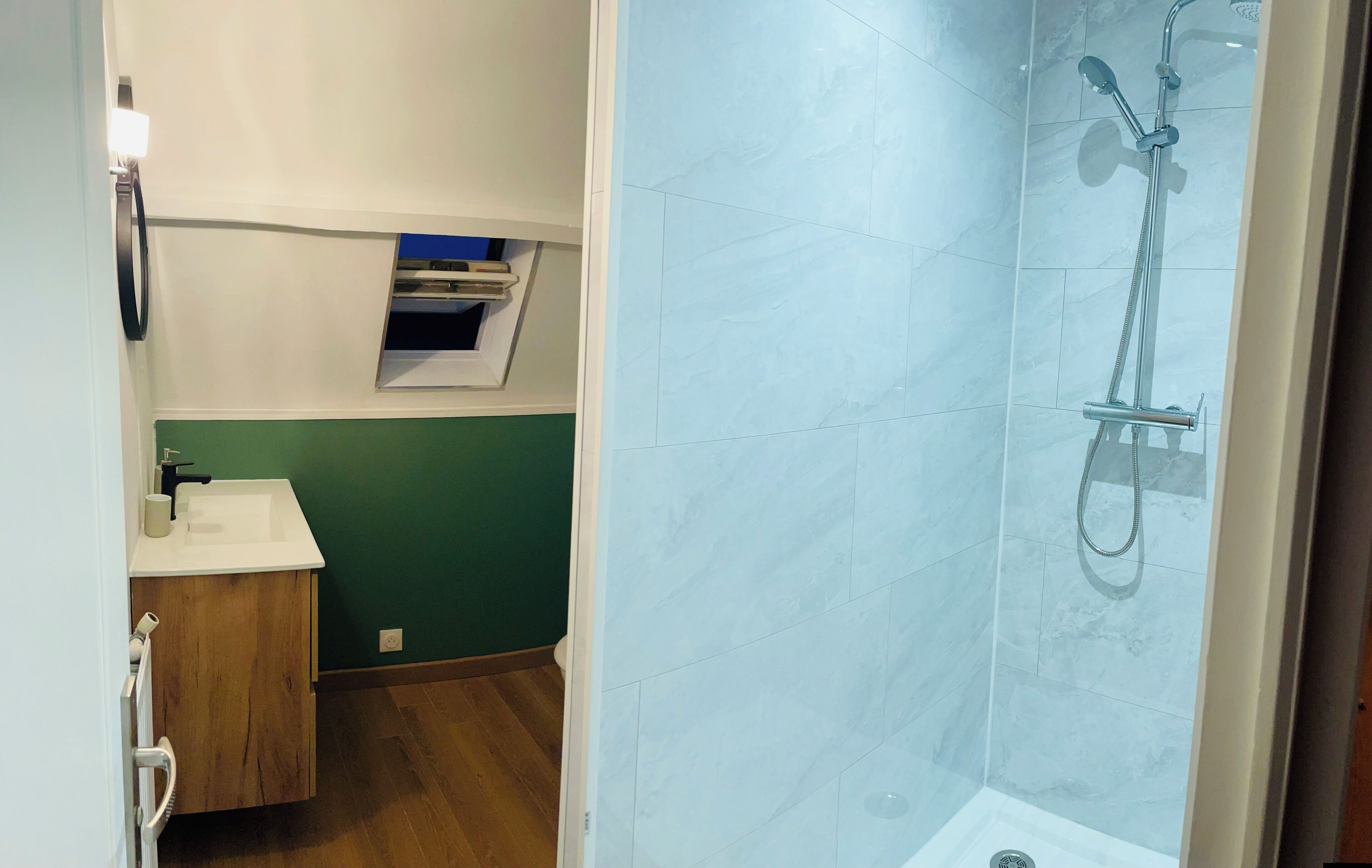 Une salle de bain avec une douche, un lavabo et un meuble en bois.