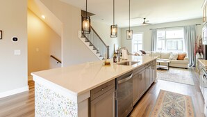 A modern kitchen with a central island, stainless steel appliances, and pendant lighting. - Southside Retreat with Coffee Bar & Garage (Chattanooga)