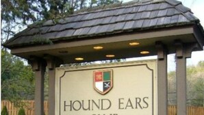 A sign for the Hound Ears Club with a logo and a garden with tulips. - Elk Watch at Hound Ears (Boone)
